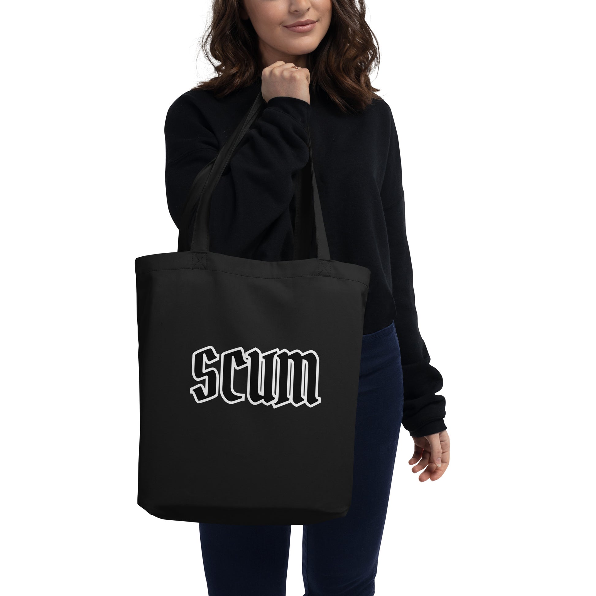 a woman holding a black tote bag with the word scum printed on it